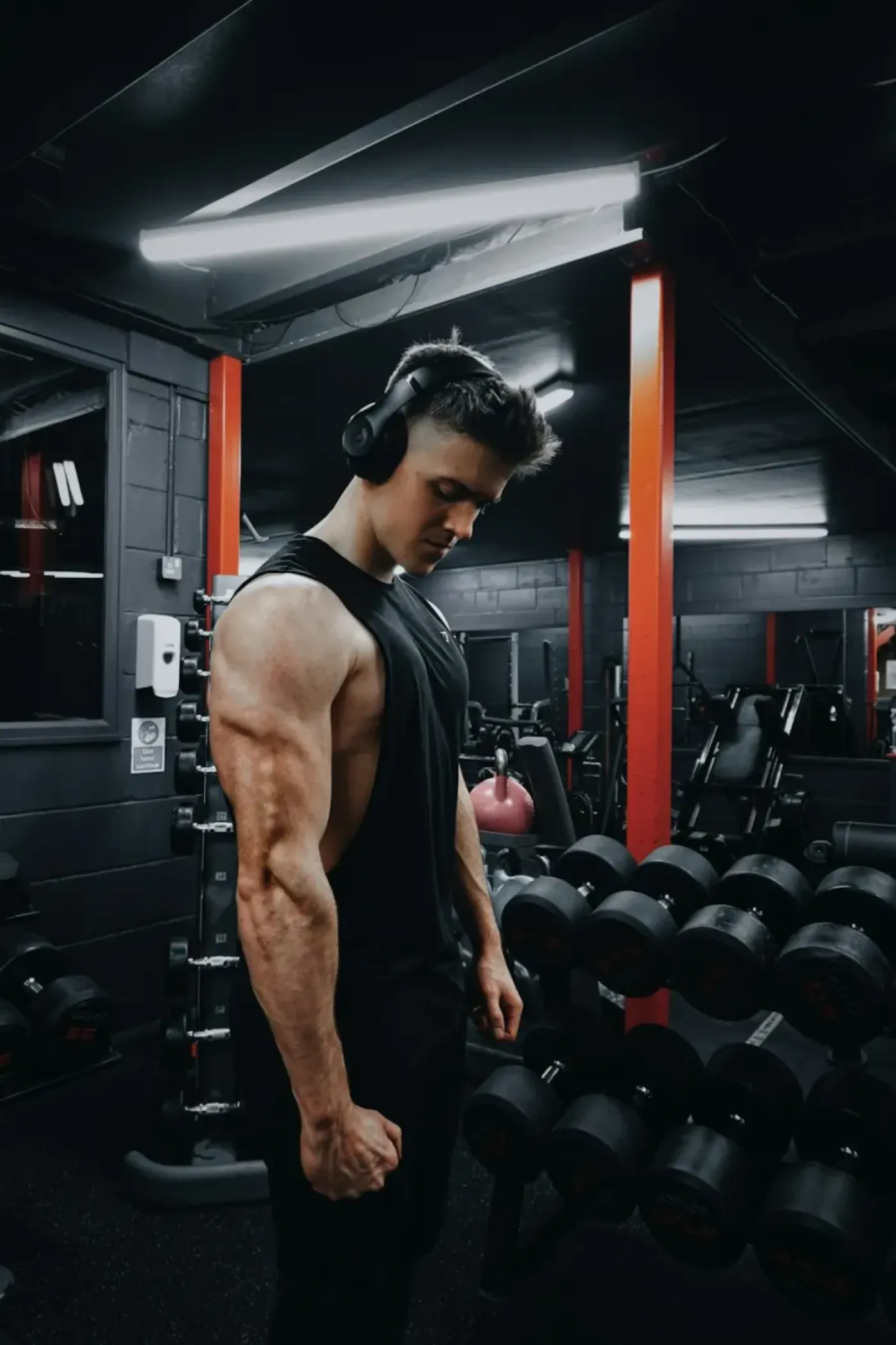 Athlete with headphones focusing before training at the gym.